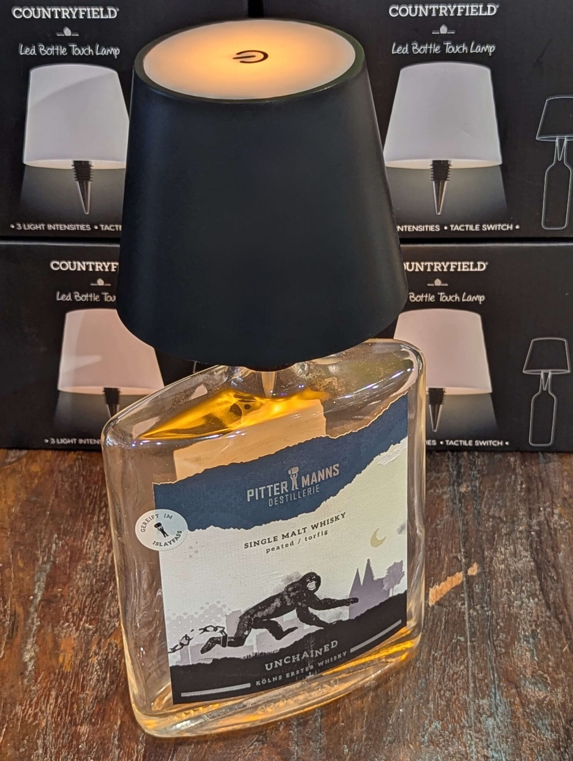 Schwarze Touch LED Flaschenlampe von Countryfield auf einer Whiskyflasche. Warmes Licht, Touchfunktion mit dimmbaren Stufen – dekorative Beleuchtung für den Innenbereich.